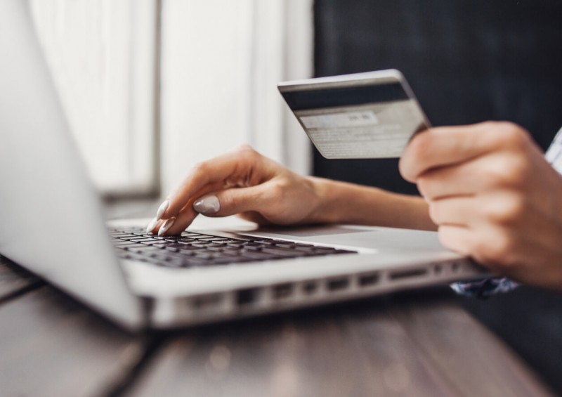 A close up of woman using her laptop and holding credit card