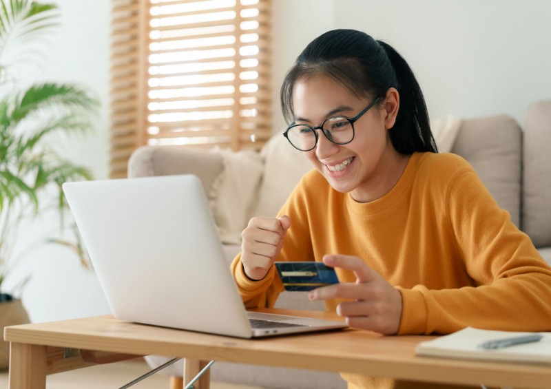 A happy young woman looking on her laptop