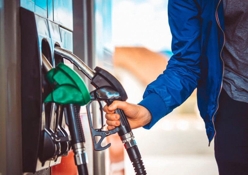 A man lifting the petrol nozzle to fill his car