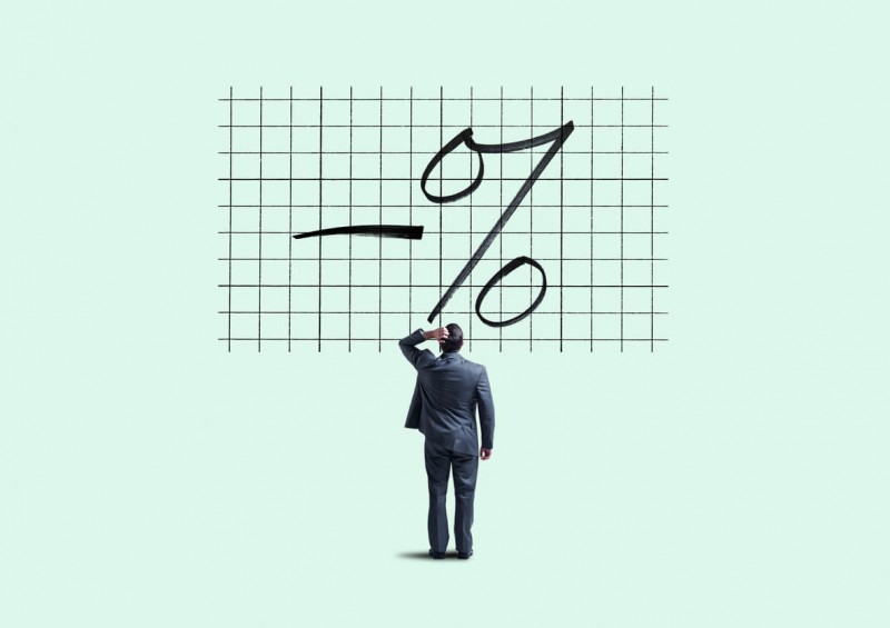A man looking at a giant minus and percentage sign