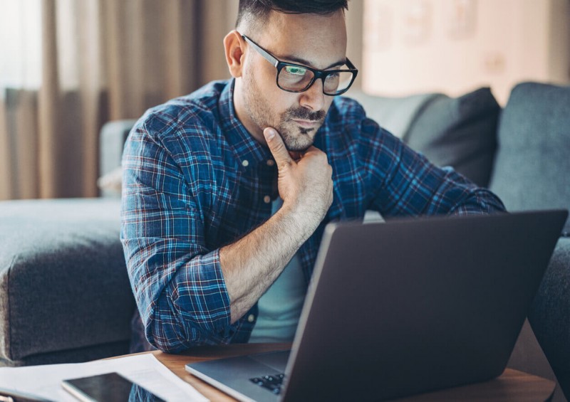 A man looking concerned at his laptop