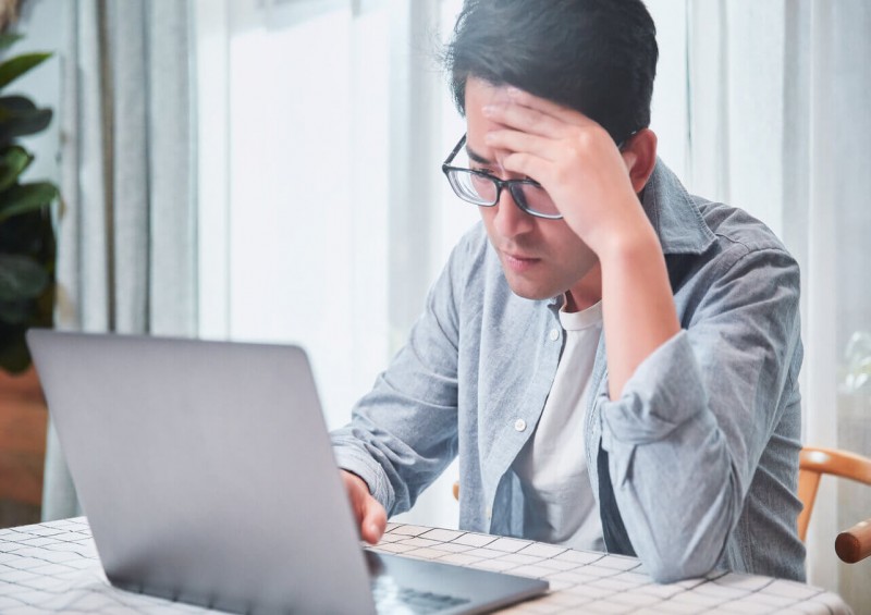 A man looking confused at his laptop