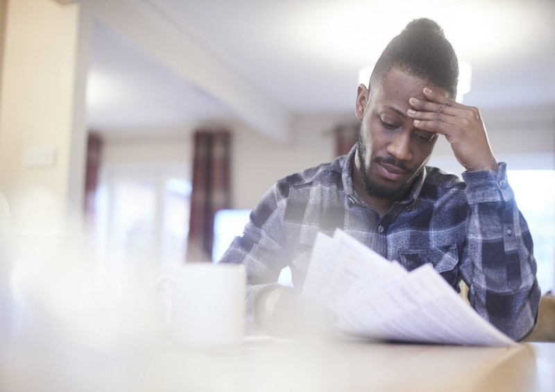 A man looking worried at his bills