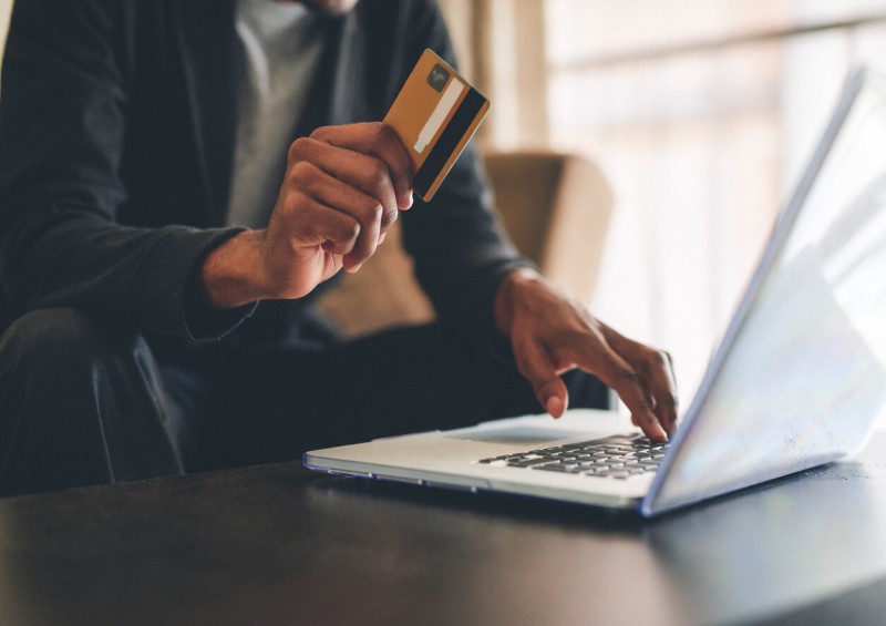 A man using his laptop and holding a credit card