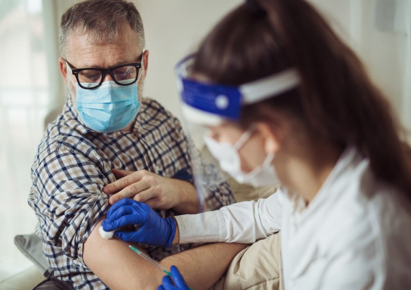 A middle aged man having the covid 19 vaccine