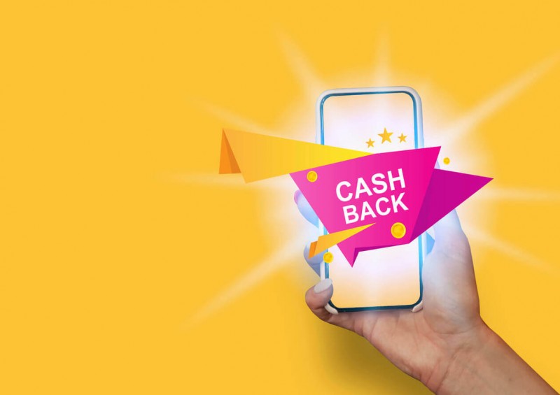 A person holding mobile phone with CASH BACK on screen