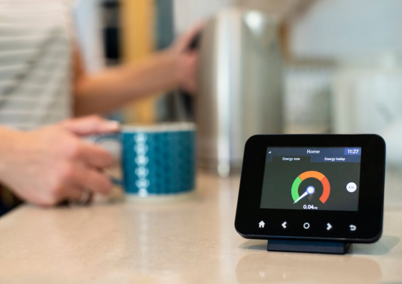 A smart meter with kettle and mug in background
