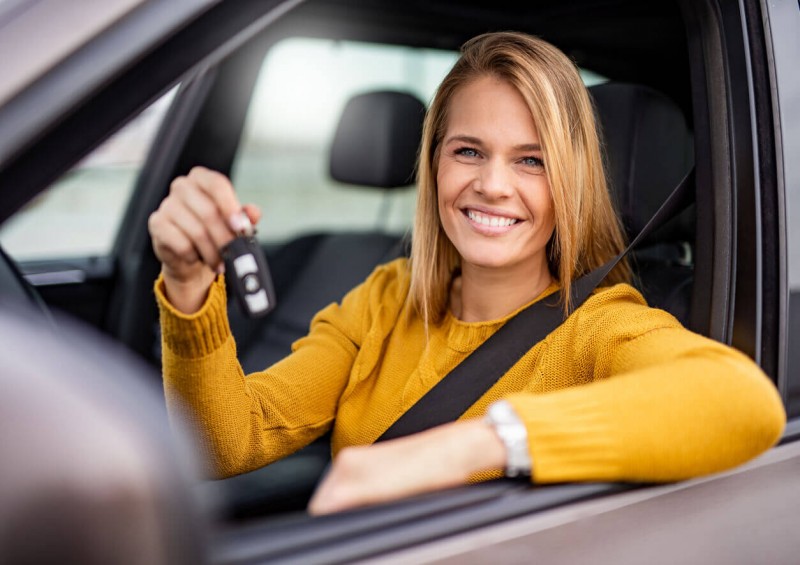 A woman holding the keys to her new car