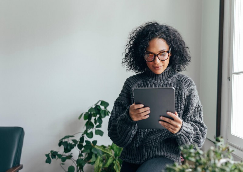 A woman in her home looking on her tablet