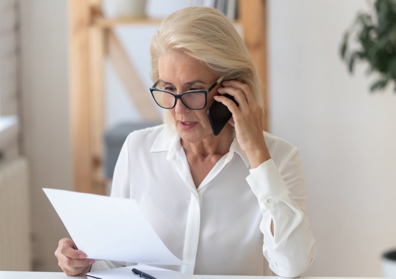 A woman on the phone while looking at a document