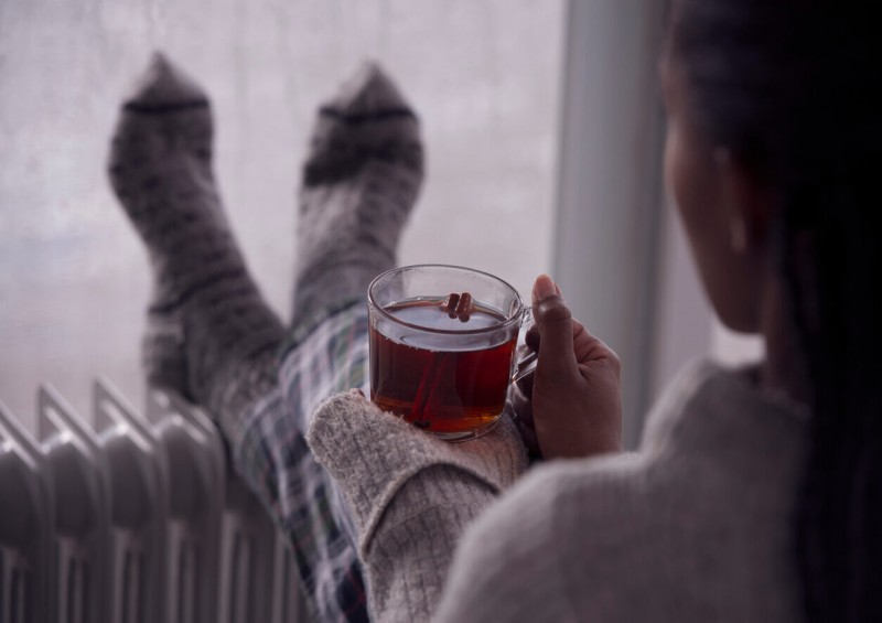 A woman with her feet resting on the radiator