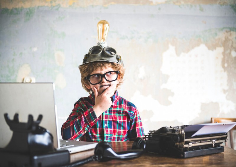 A young boy with a lightbulb on his head and thinking