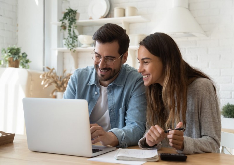 A young couple looking excited and happy while on laptop