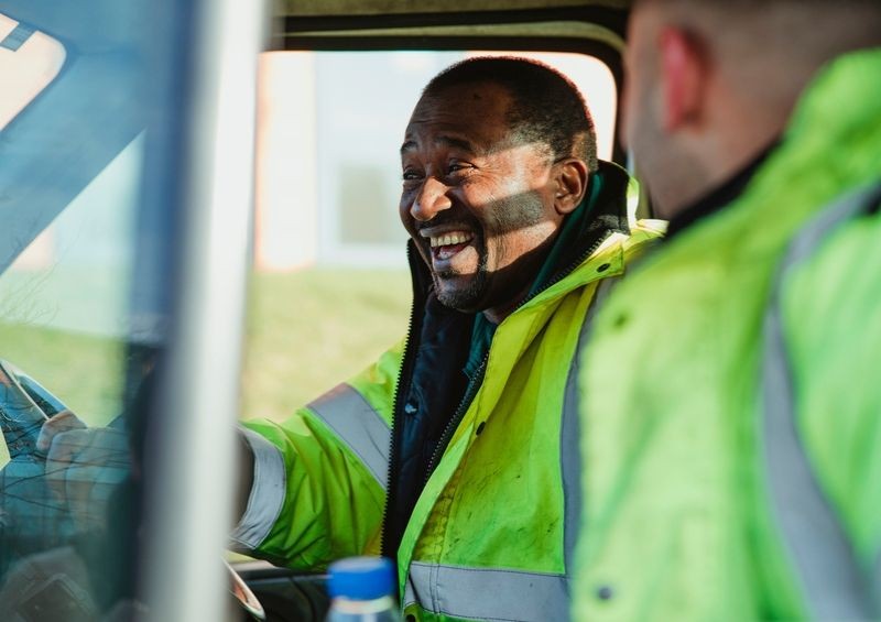 Builders in hi vis laughing while driving