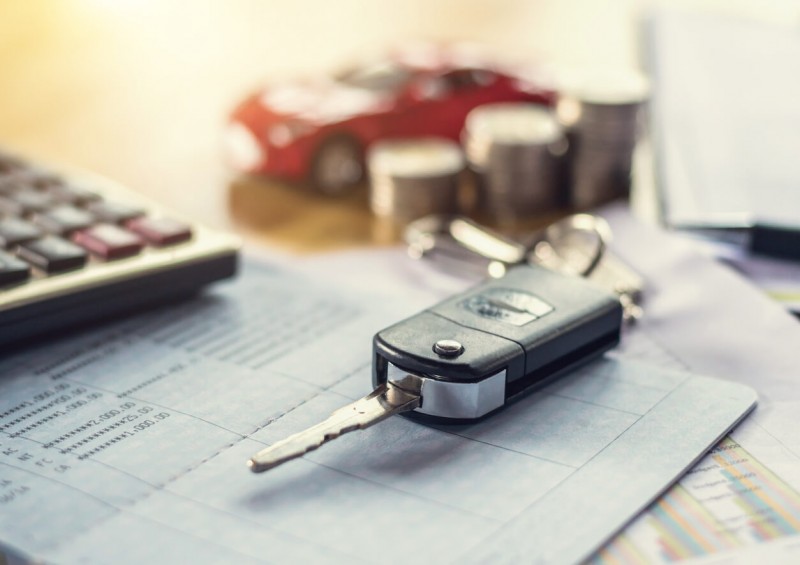 Car keys next to calculator and contract