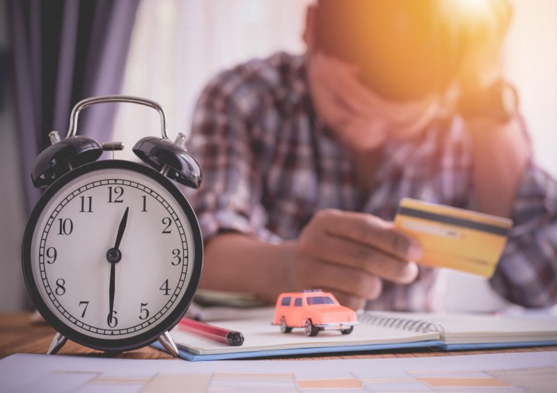 Clock and man stressed about finances