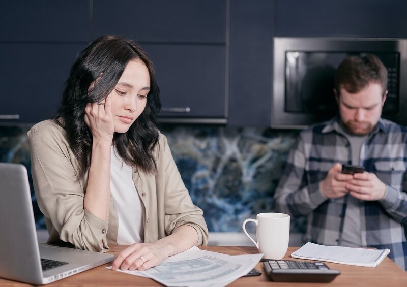 Couple sat at table looking at car insurance bills