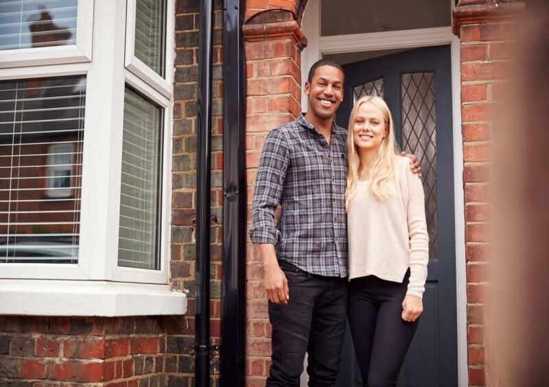 Couple standing outside new home