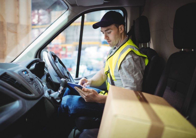 delivery driver in van with package