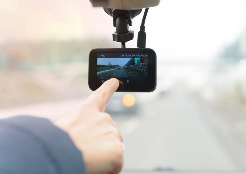 Driver starting dash cam on windscreen