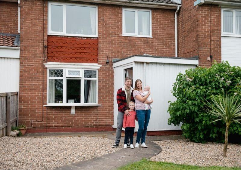 Family outside a typical house