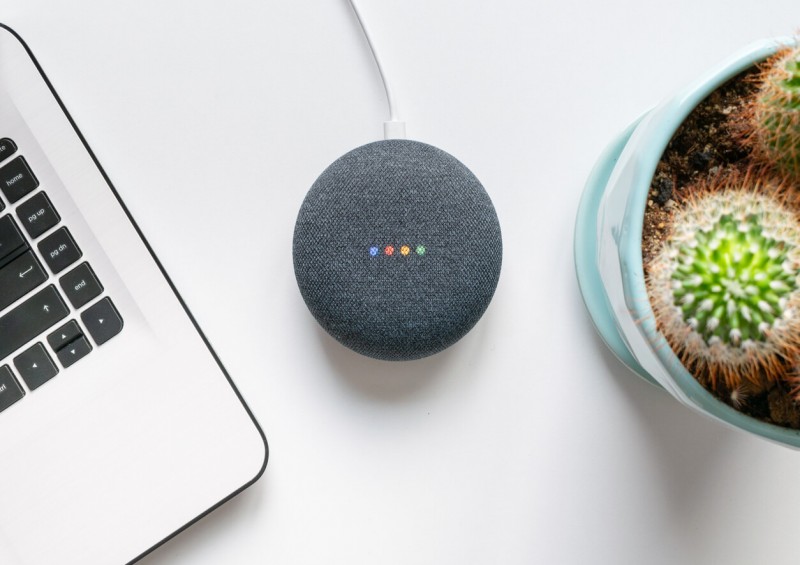 Google Home Mini next to laptop