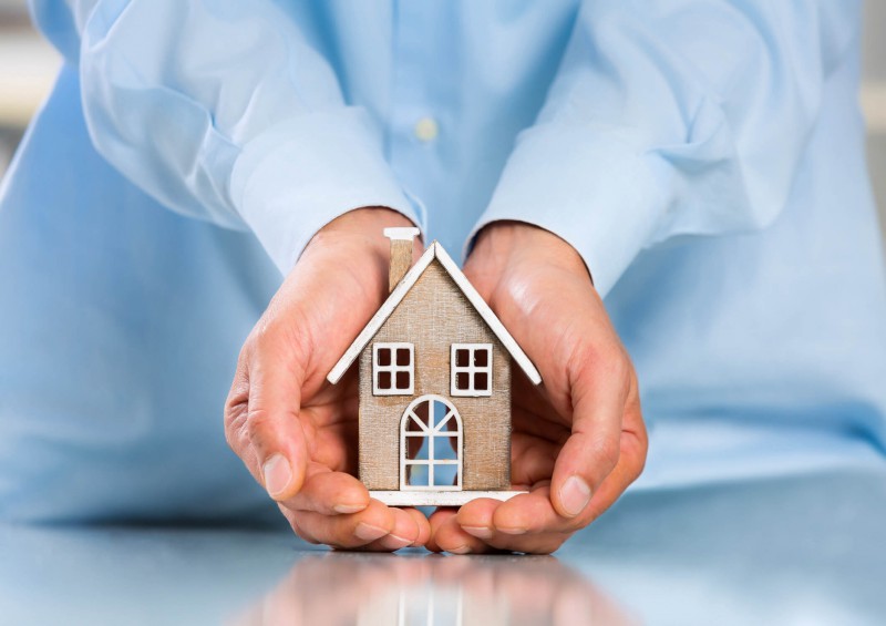 hands cupping toy house