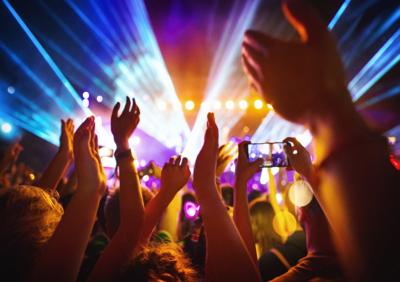 Hands in the air dancing by festival stage at night