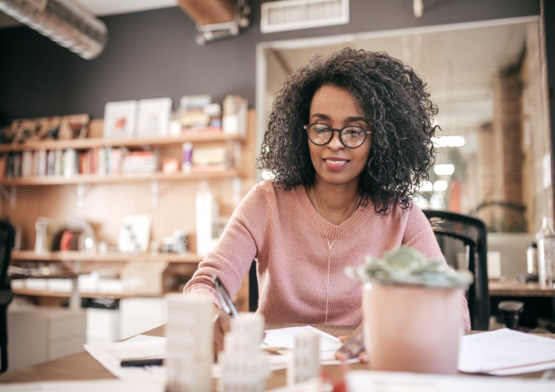 Happy woman sorting out her finances at a table