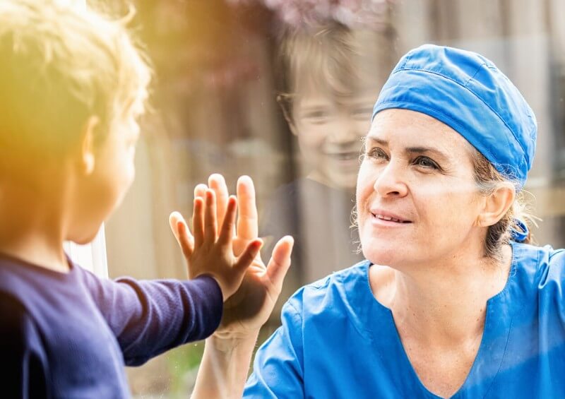 Healthcare NHS worker with child through window