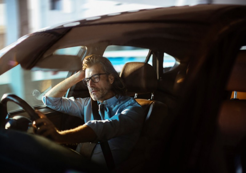 Male driver bored while commuting in car