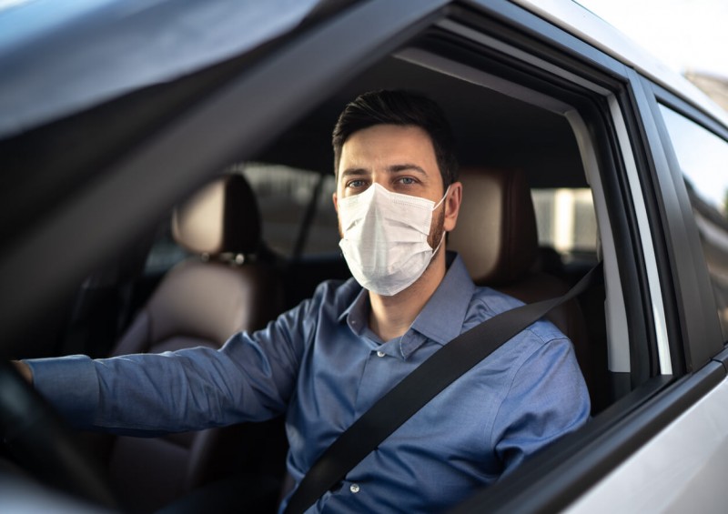 Man driving a car with a face mask on
