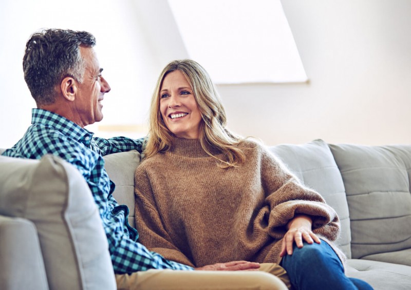 Middle aged couple sat on a sofa