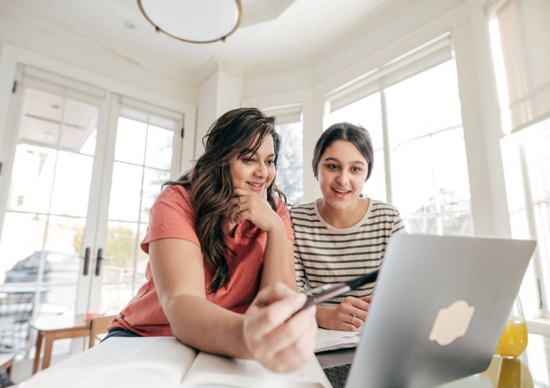 Mother teaching teenager about finances