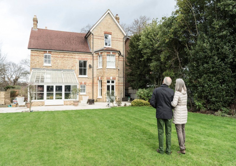 Older couple looking at their home from their garden