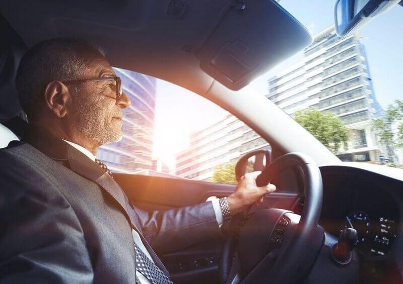 Older man driving through city