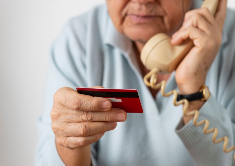 Older man giving bank details to scammer over phone