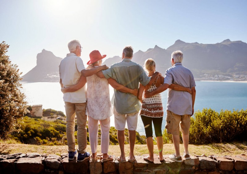 Older people standing in front of sea on holiday
