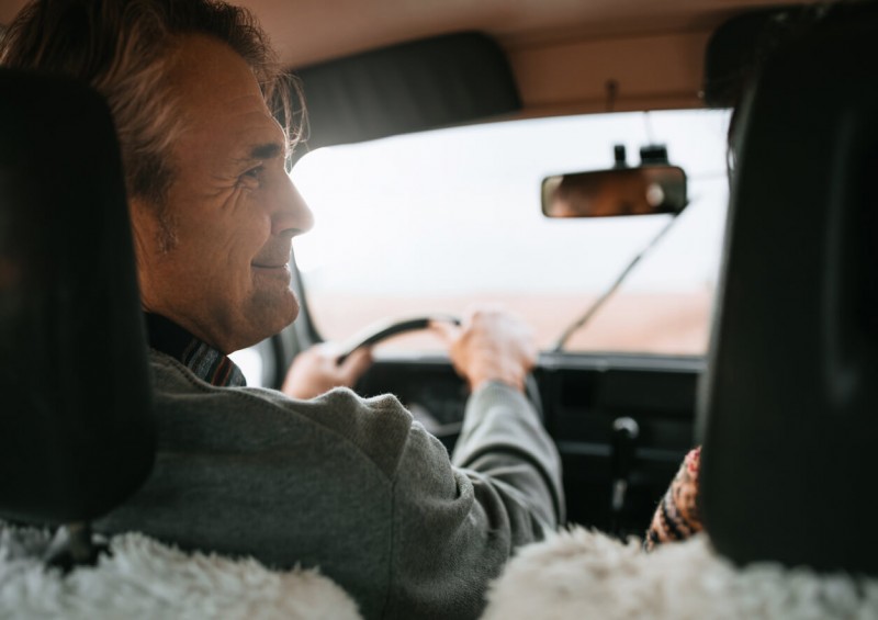 Over 50 year old happily driving his car