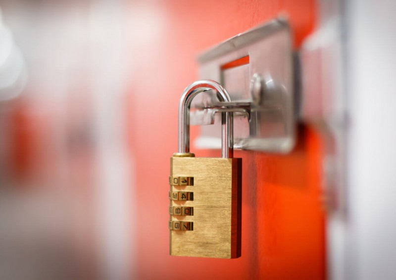 Padlock on an orange door inside a storage unit