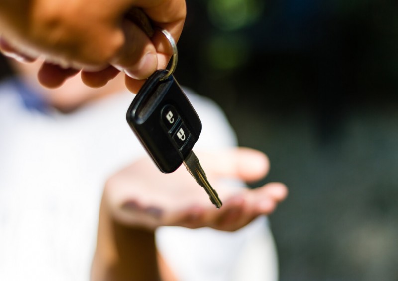 person handing car keys to another person
