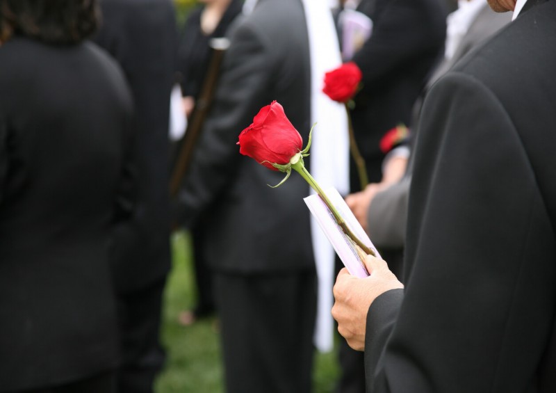 Person holding flower at a funeral