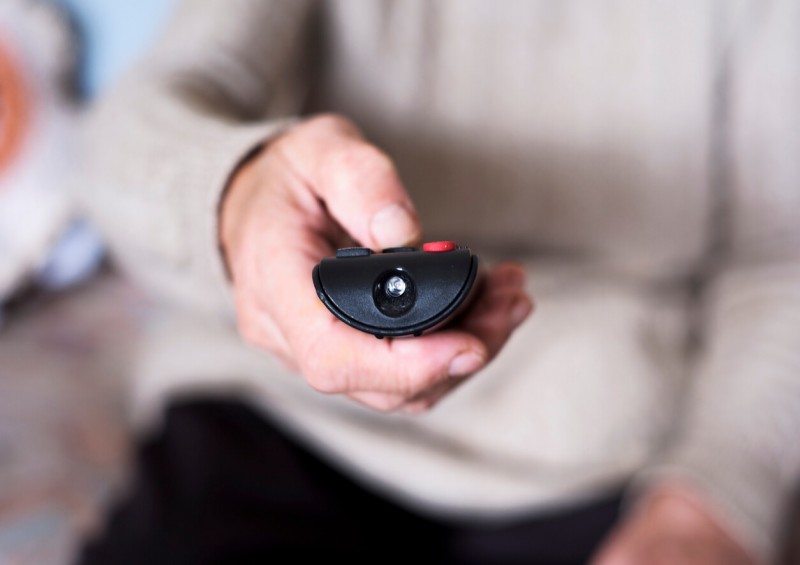 Person holding TV remote control