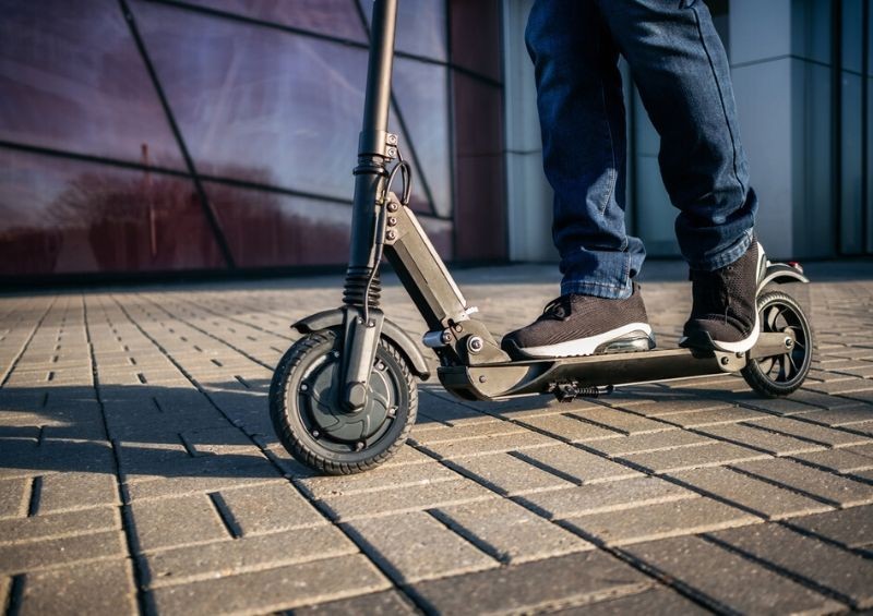 Person riding electric scooter on street