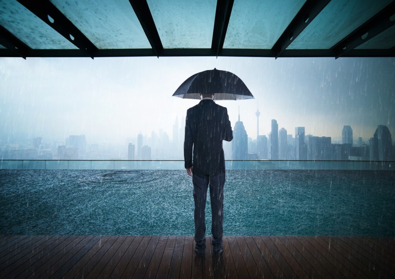 protecting business man with umbrella