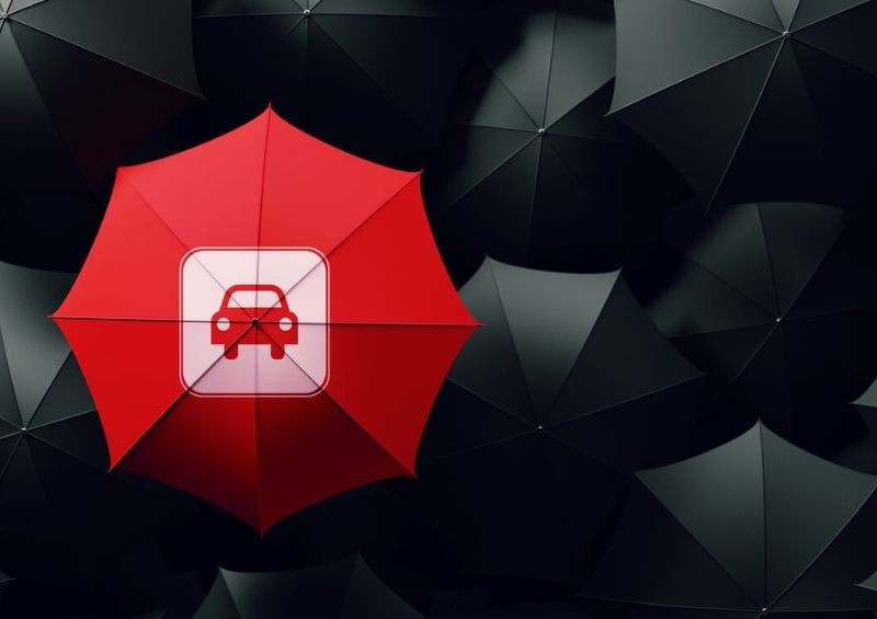 Red umbrella car in the centre surrounded by black ones