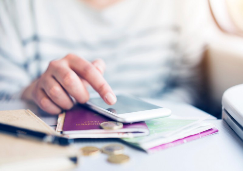 Someone sorting out their passport and money at a desk