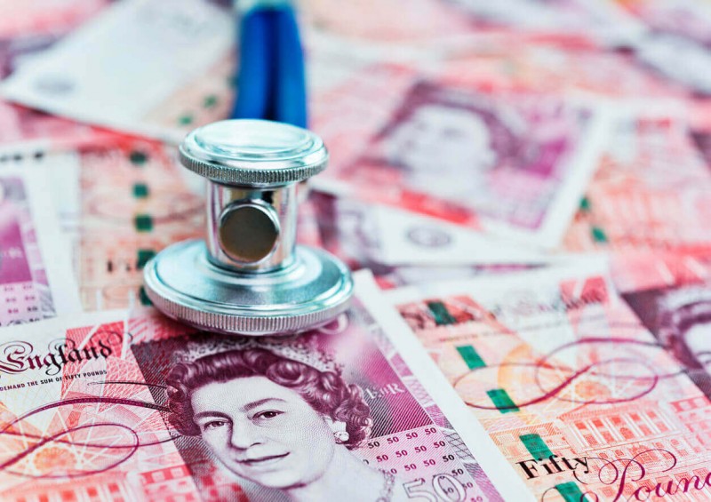Stethoscope on top of English money