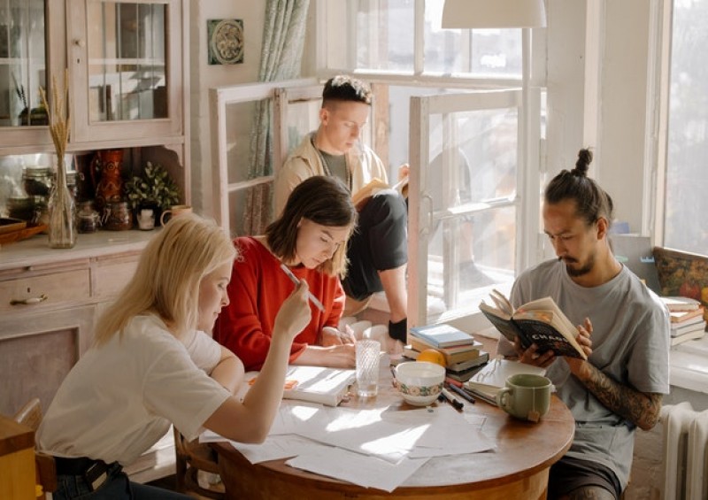 Students sat around table in kitchen