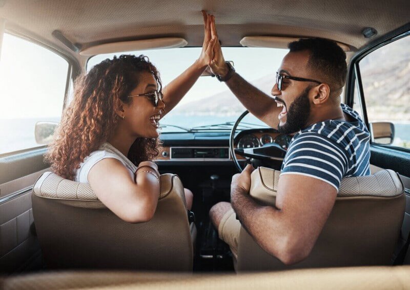 Two people looking very happy in their car